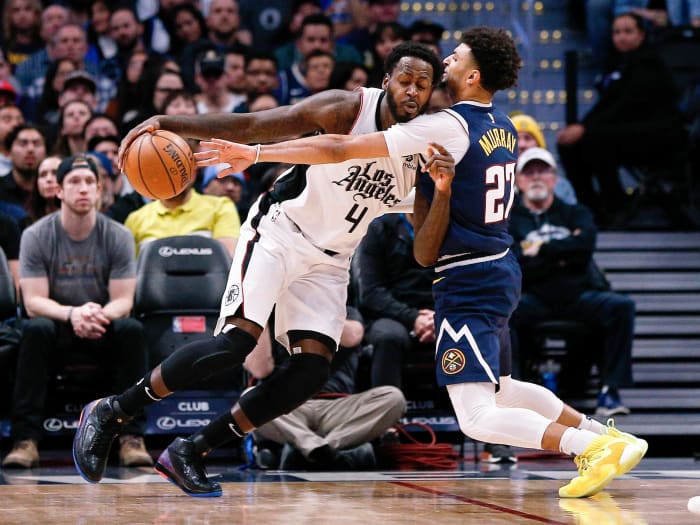Jan 12, 2020; Denver, Colorado, USA; Los Angeles Clippers forward JaMychal Green (4) controls the ball as Denver Nuggets guard Jamal Murray (27) guards in the second quarter at the Pepsi Center.
